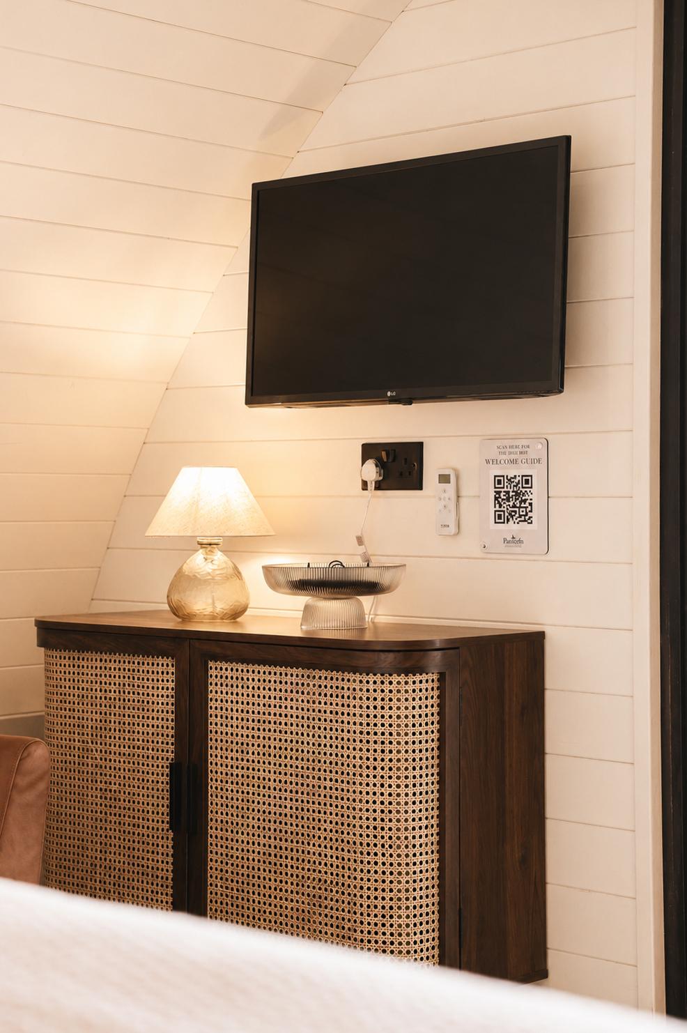 Rattan-fronted sideboard with TV and welcome guide