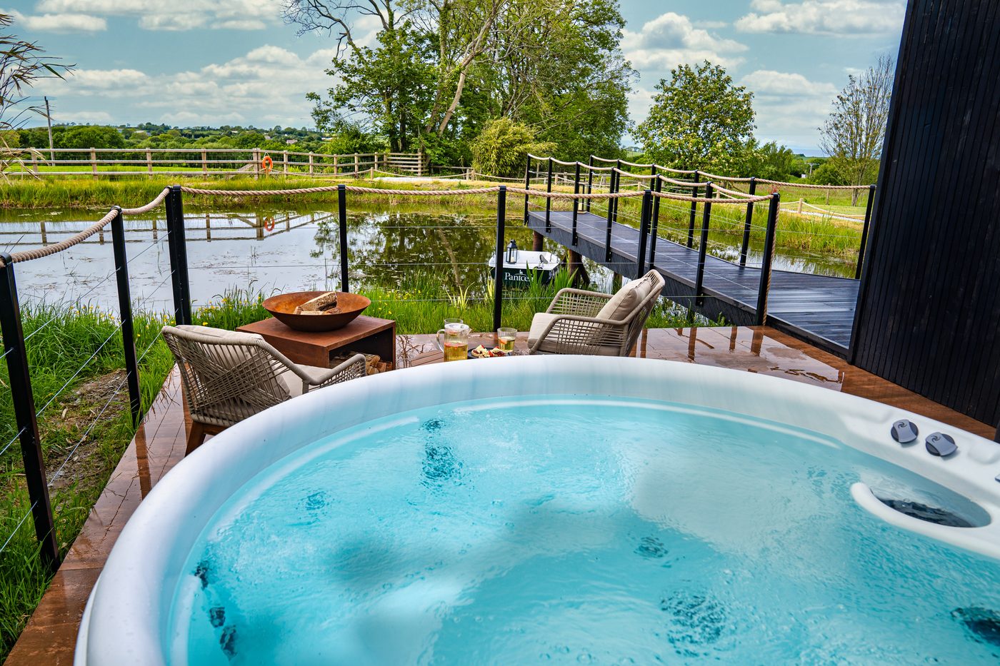 Hot tub looking out across the private lake and rope-rail boardwalk from the Boathouse