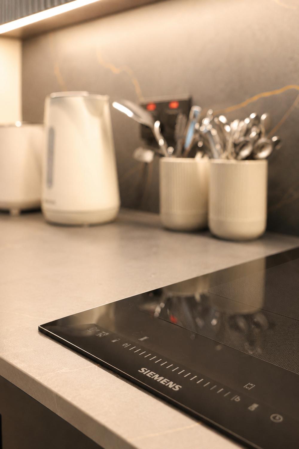 Cutlery and kitchen utensils on the marble worktop