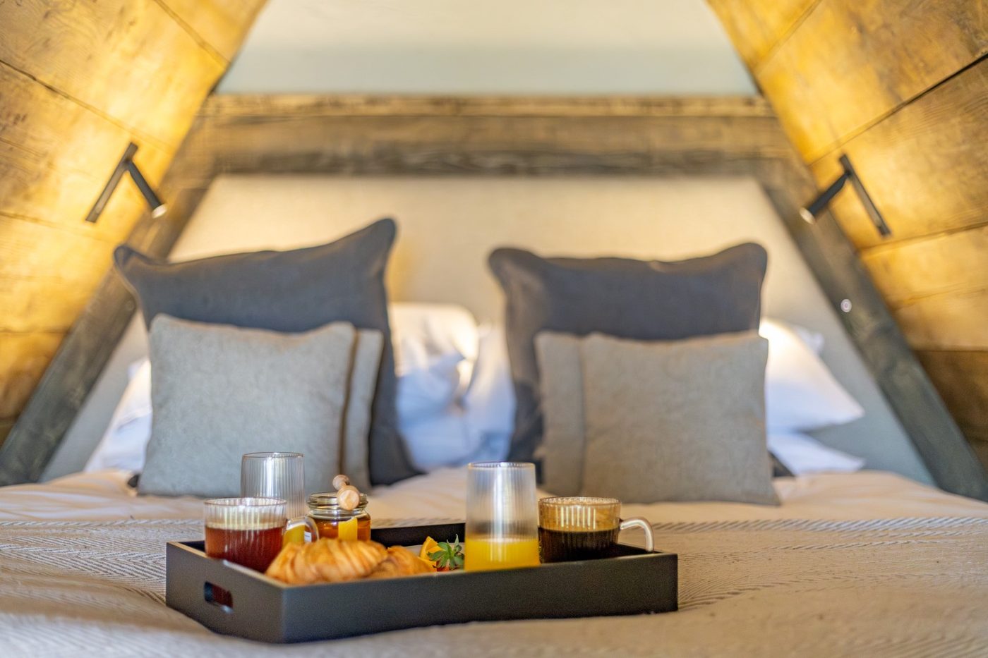 Breakfast tray on the Tri-Pod bed — croissants, juice and coffee in the apex