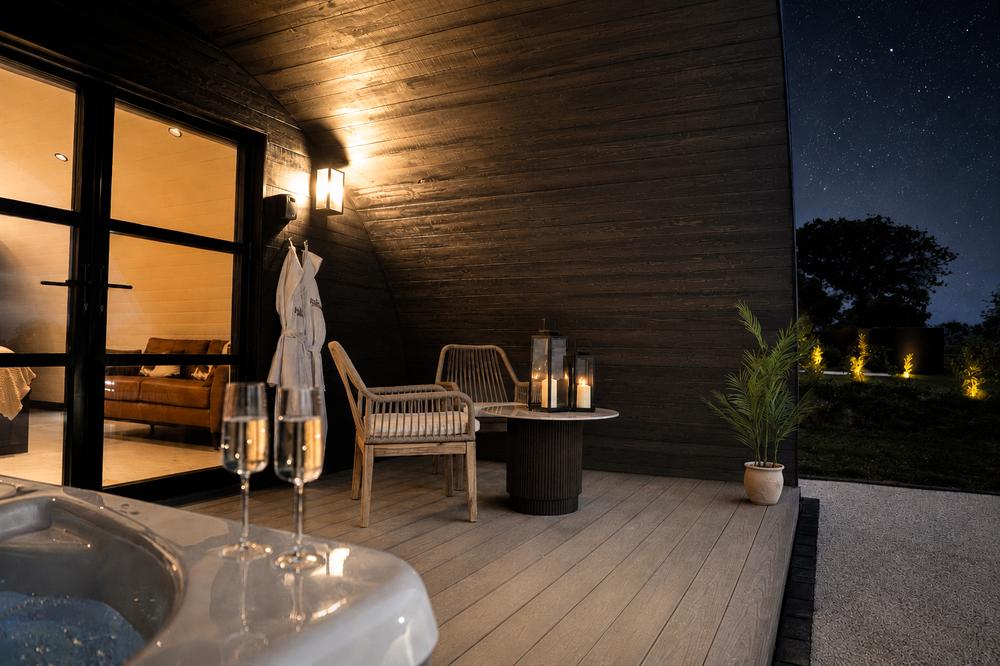 The hot tub and deck after dark, champagne glasses and starlit sky
