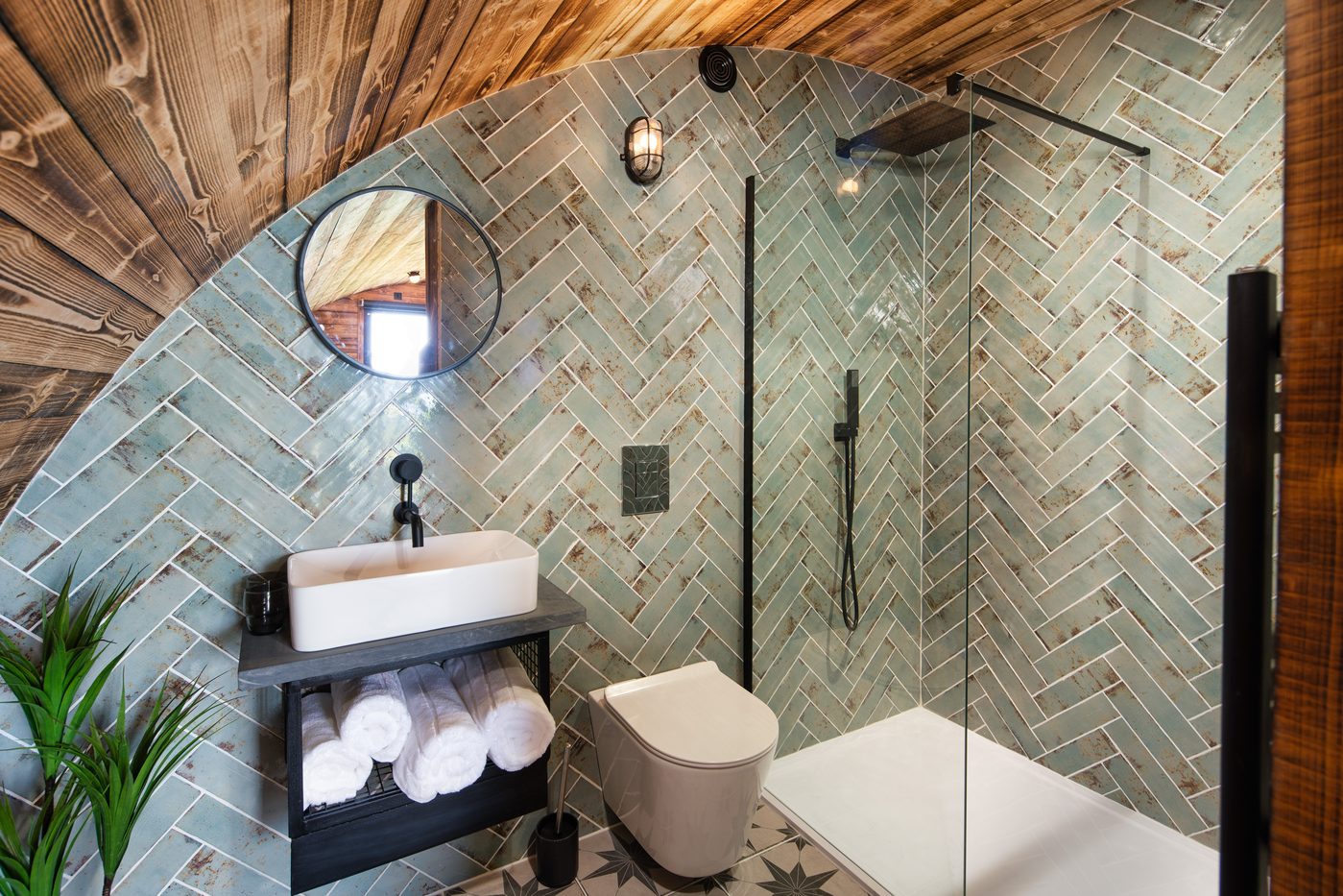 Herringbone-tiled shower room in the Piglet Pod with rainfall shower